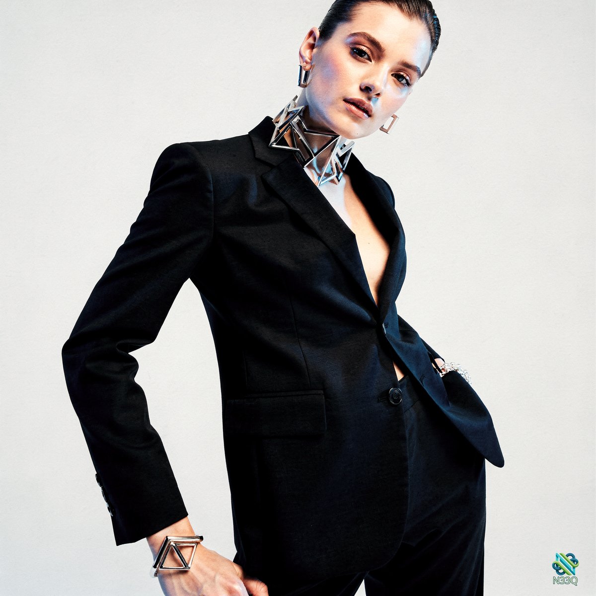 Woman in Black Pantsuit with Geometric Jewelry