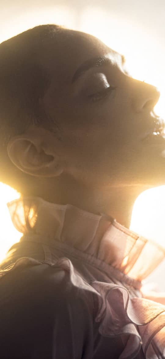 Woman with Shaved Head in Golden Halo