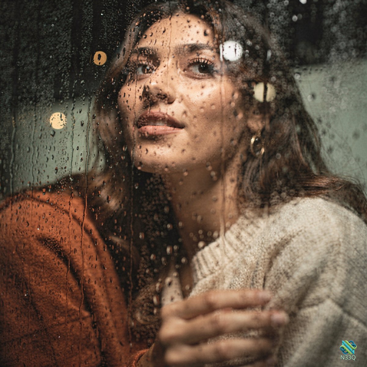 Woman Gazing Through Rainy Window Glass